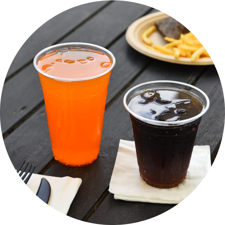 Disposable plastic cups with orange soda and cola, perfect for restaurants and cafes.